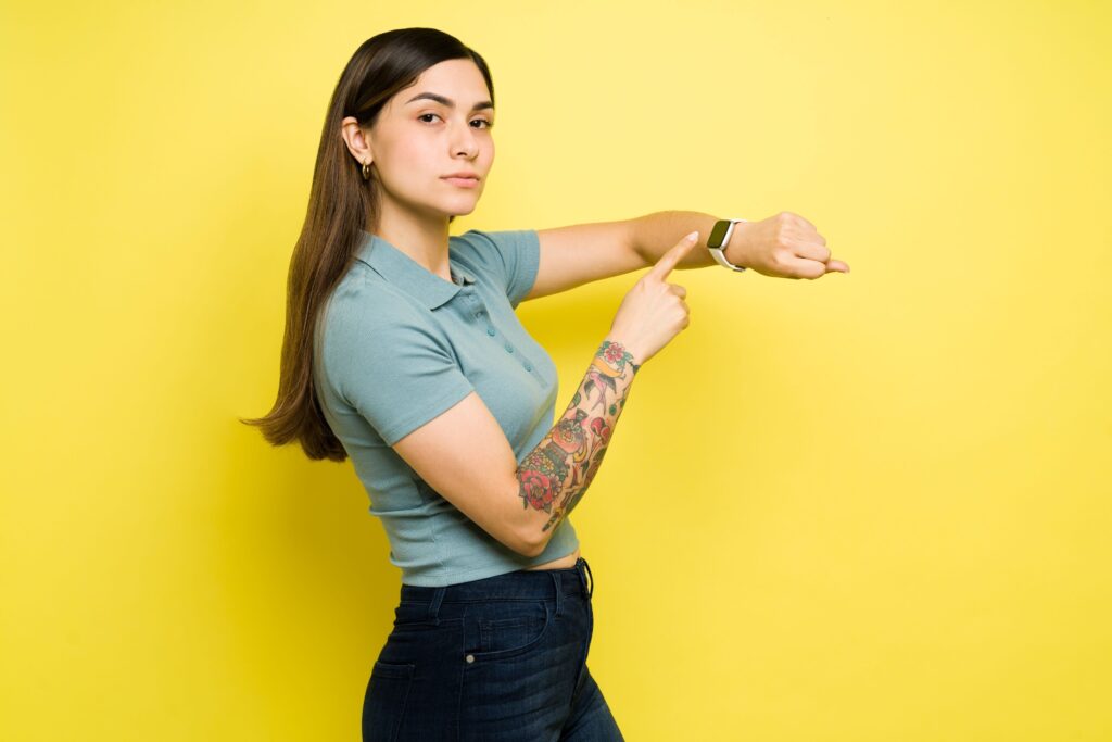 Woman pointing to the watch on her wrist