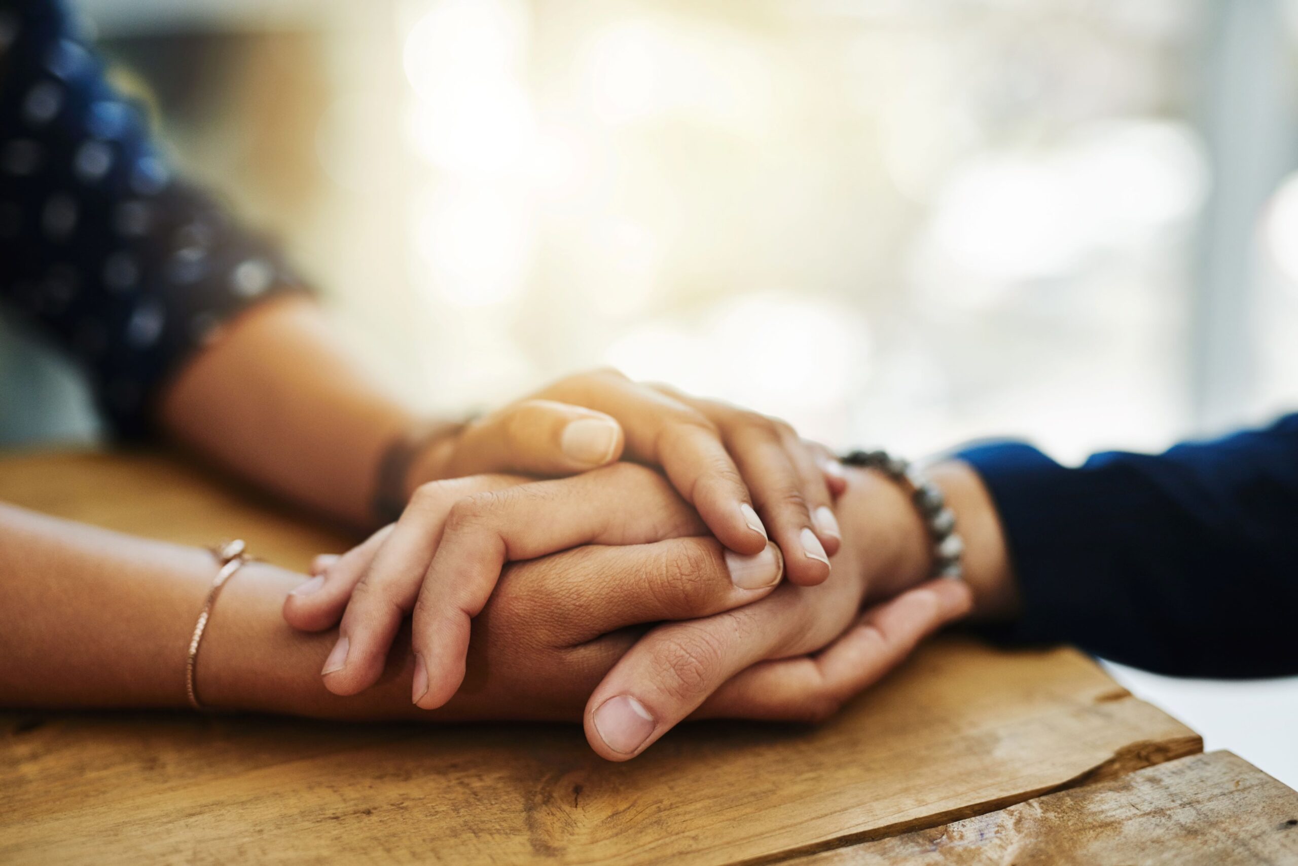 Two loved ones holding hands supportively